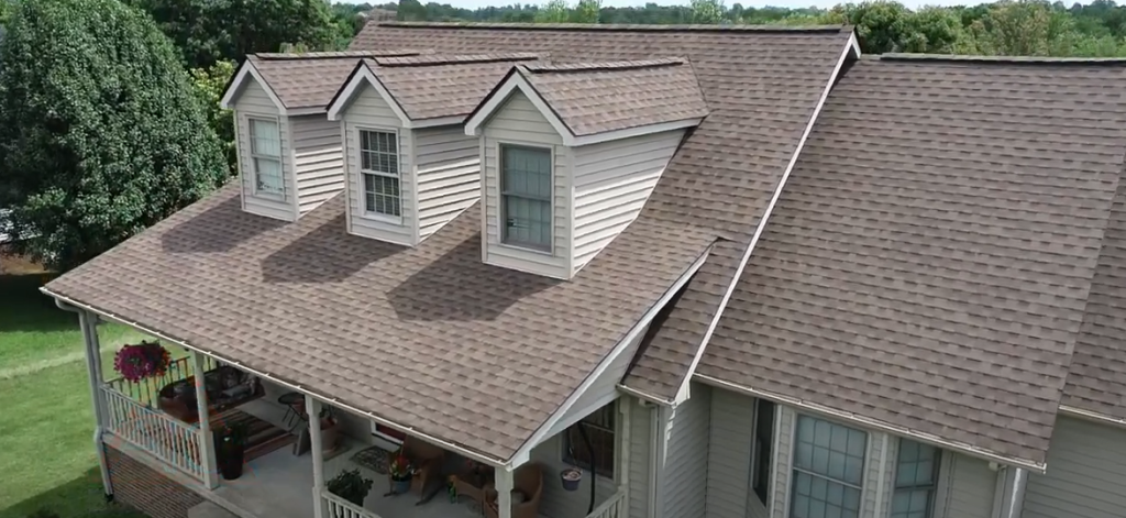 Picture of home with exterior improvements, including a rendered roof that was replaced, updated gutters and siding, and new windows.