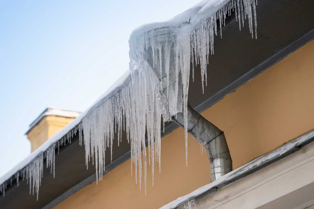 close up of an ice dam on a home, representing a blog post for how to prevent ice dams and protect your home