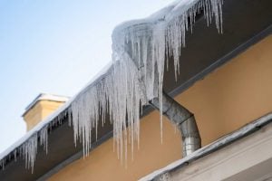close up of an ice dam on a home, representing a blog post for how to prevent ice dams and protect your home