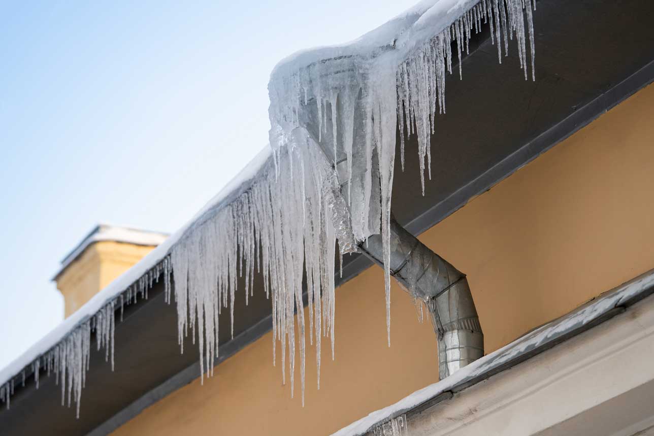 close up of an ice dam on a home, representing a blog post for how to prevent ice dams and protect your home